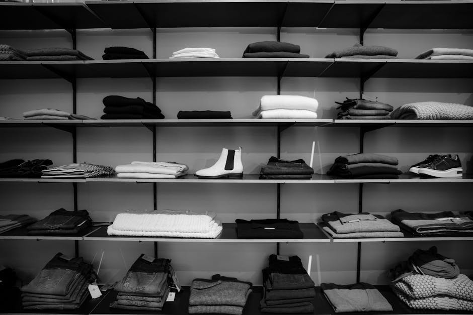 pexels-photo-1884581-1884581 Neatly folded clothing and shoes displayed on shelves in a boutique setting.
