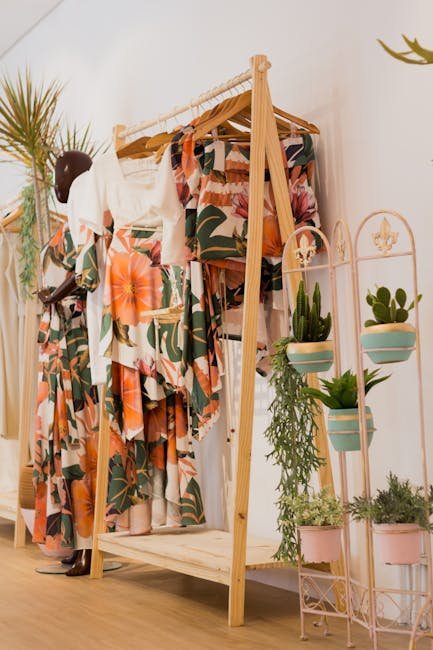 pexels-photo-3489129-3489129 Floral print clothing elegantly displayed in a modern boutique with lush green plants for decoration.